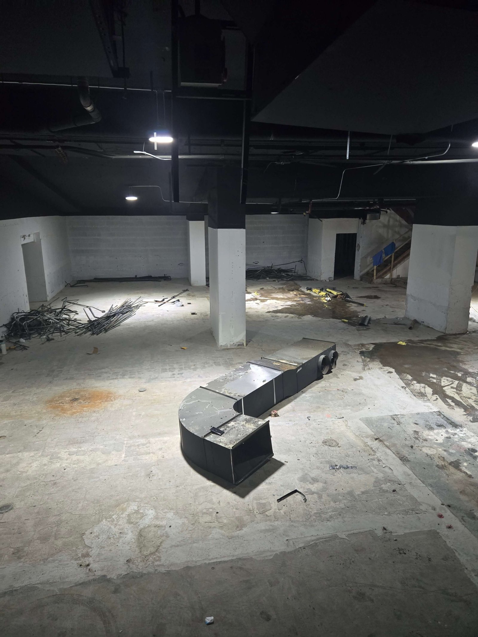 Commercial interior demolition with ductwork and debris staged for removal