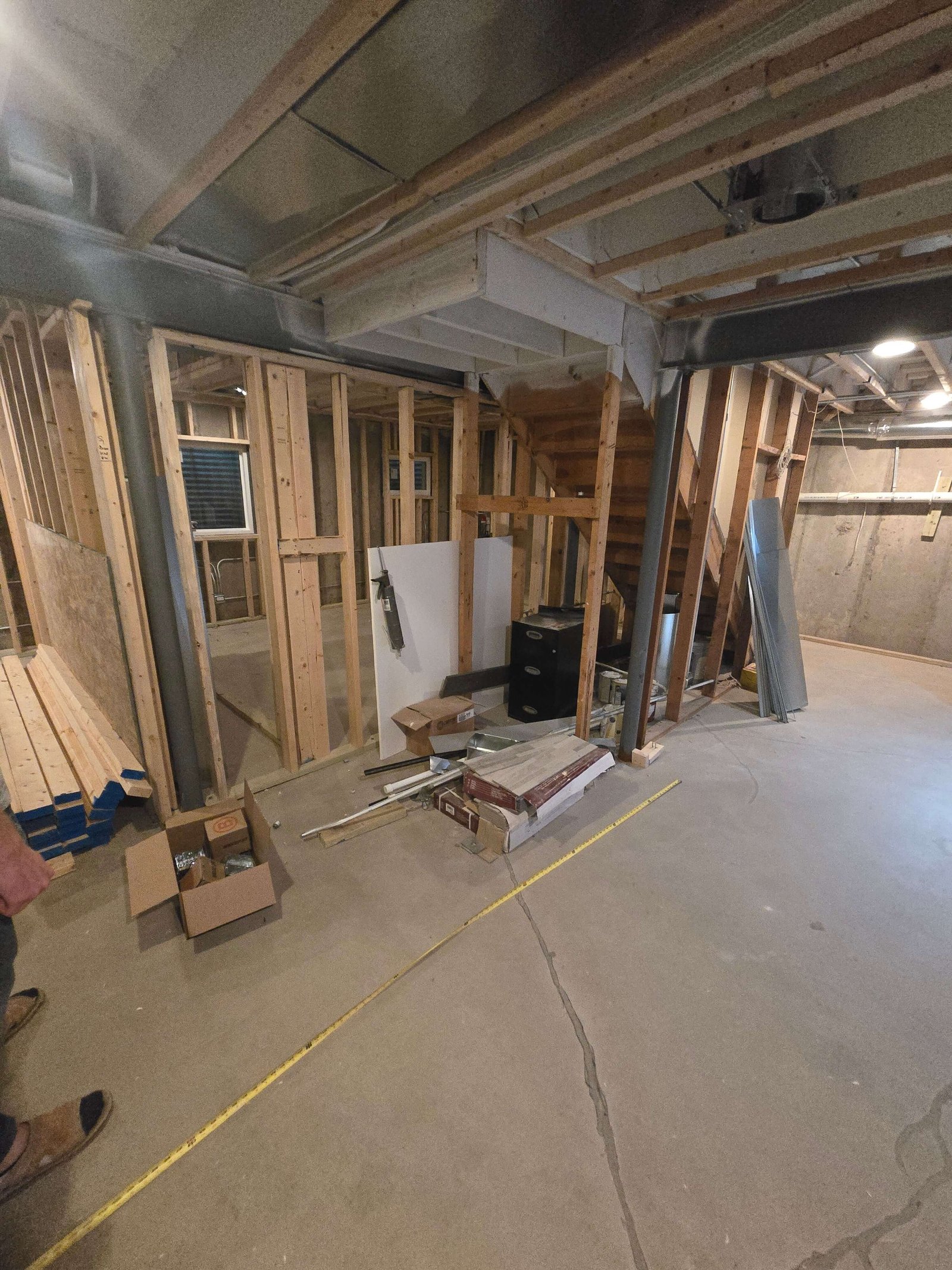 Basement framing and rough-in progress with open staircase