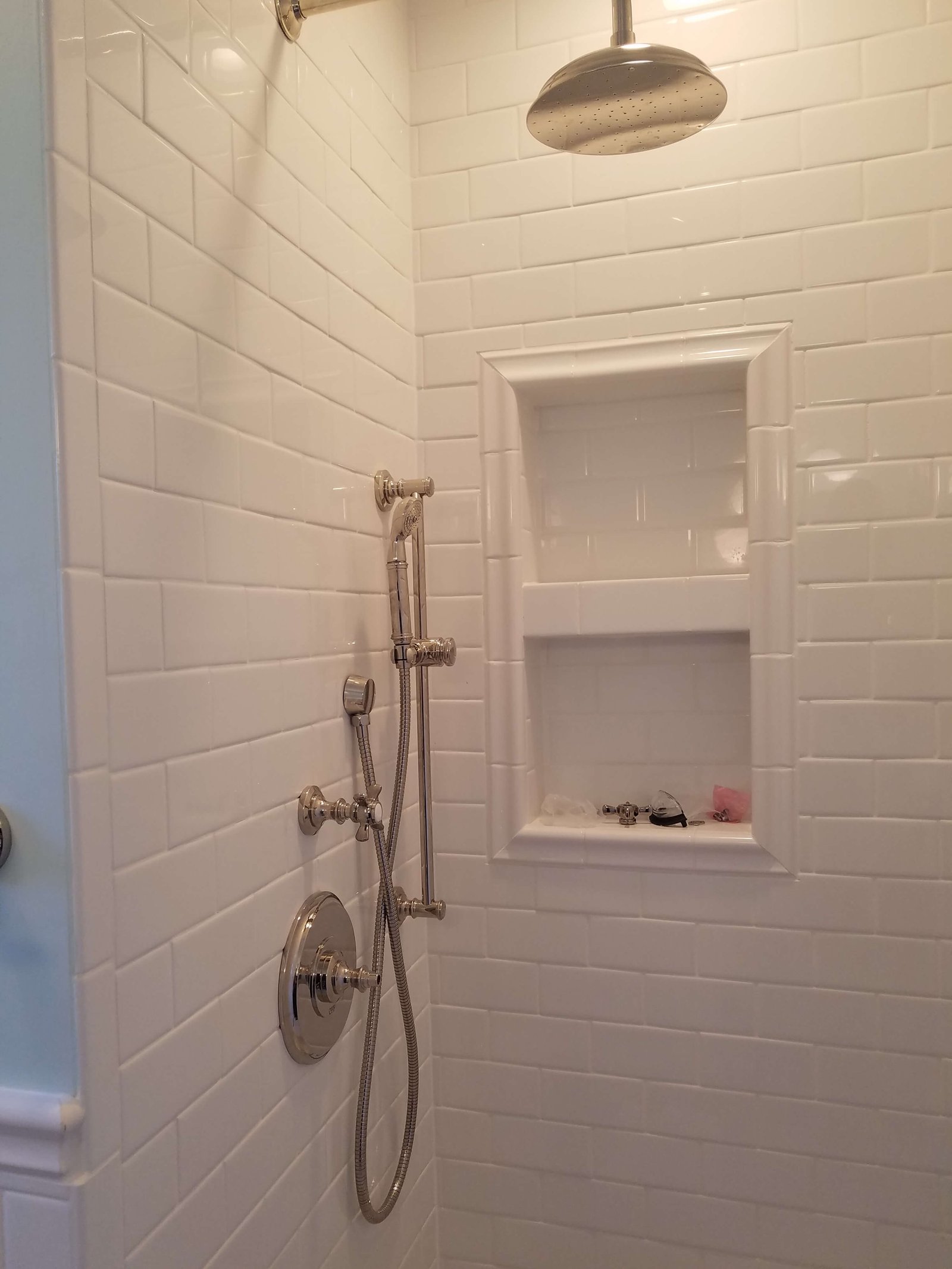 Finished bathroom shower with subway tile and chrome fixtures