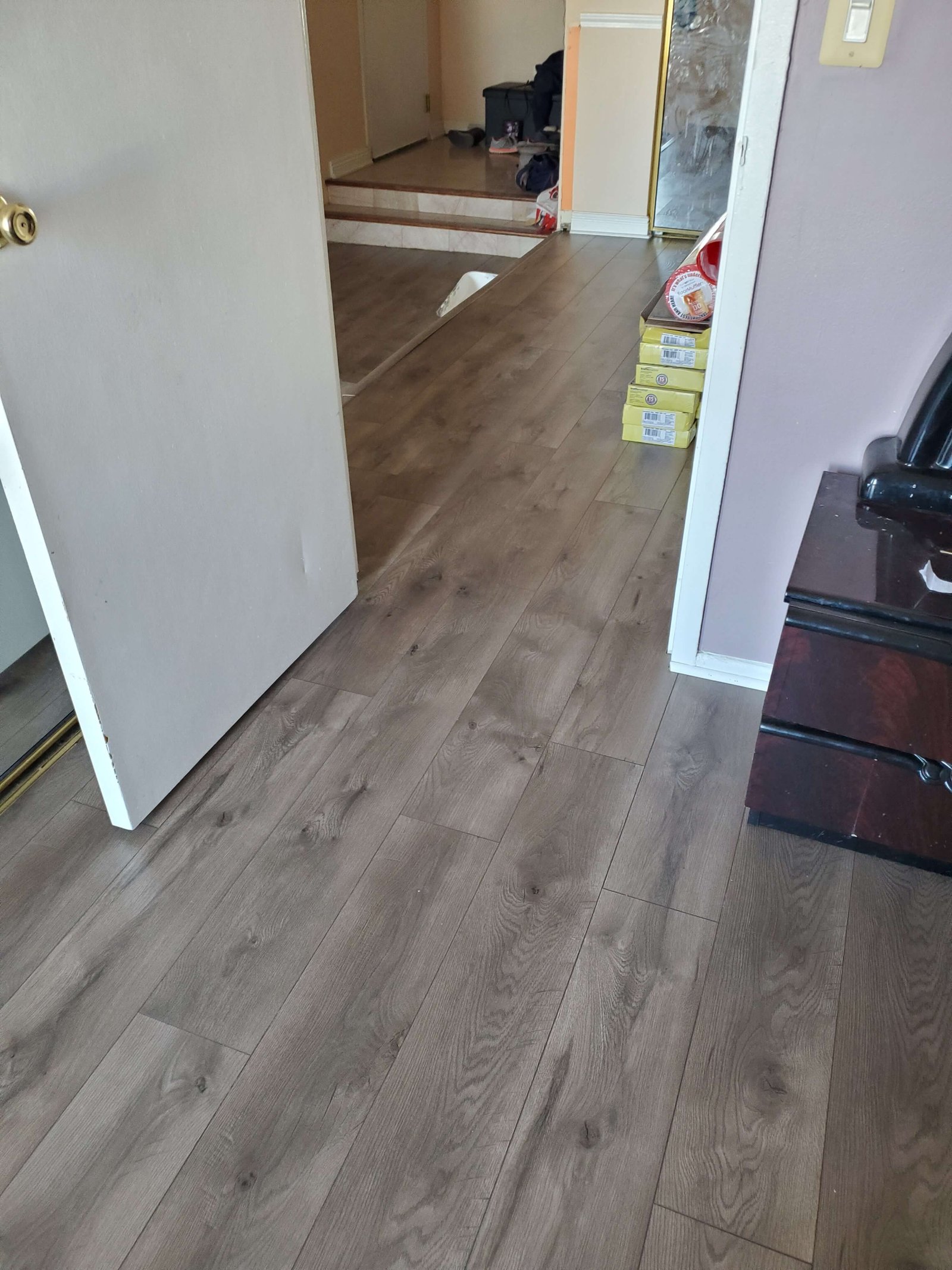 Hardwood flooring installed through a hallway and adjoining rooms