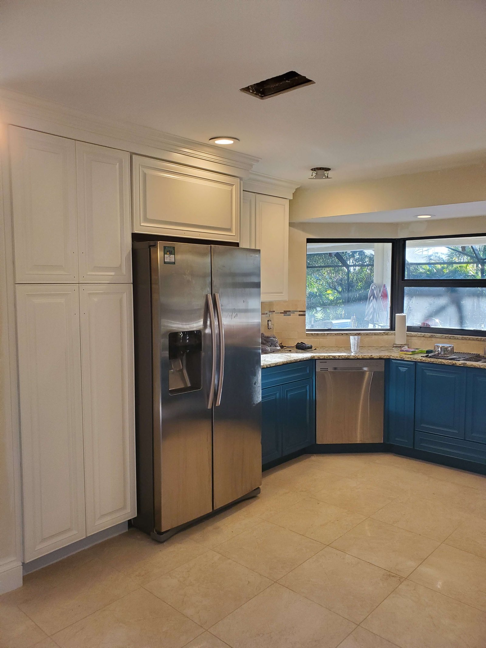 Repainted kitchen cabinets in white and teal finishes